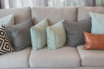 set of pillows on modern cozy grey sofa