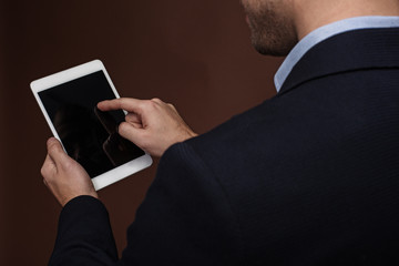 Top view close up man arm typing in screen of gadget. He keeping it in hand. Appliance concept