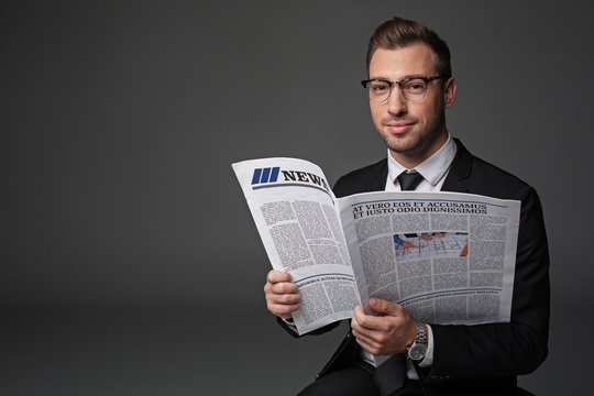 Portrait of smiling bearded businessman keeping modern newspaper. He looking at camera. Information concept. Isolated and copy space