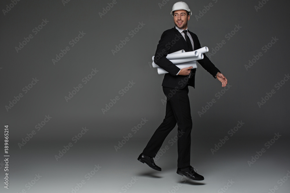 Aufkleber full length portrait of laughing architect walking while keeping projects in arms. labor concept. co