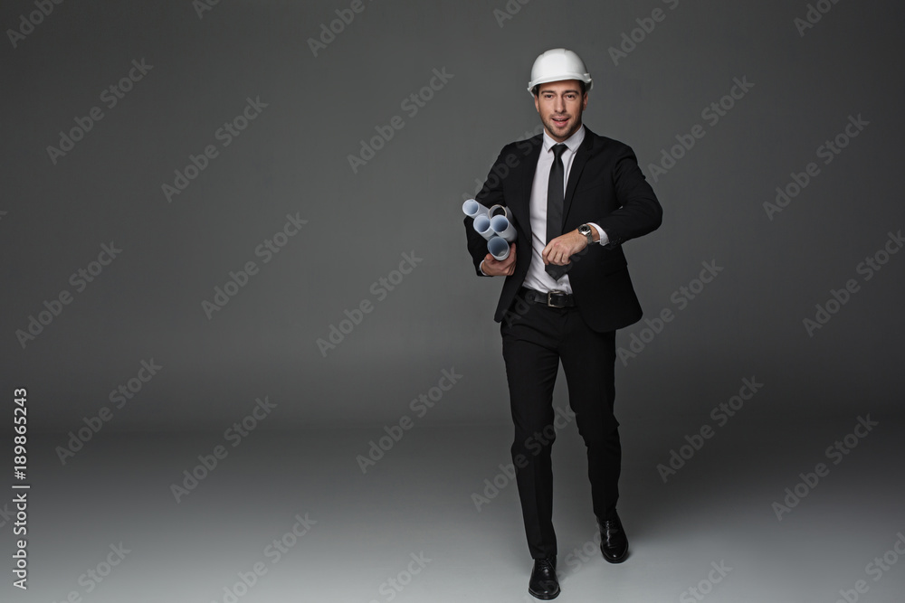 Aufkleber full length portrait of cheerful unshaven builder running while holding different documents in arm. 