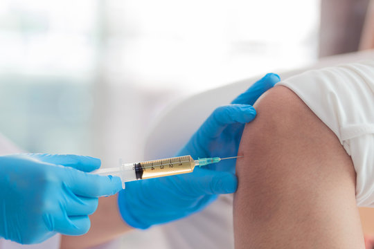 Knee joint aspiration, Hand in blues glove take a joint knee fluid sample in the hospital.