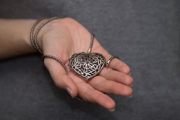 a steel heart in woman's hands as a symbol of love