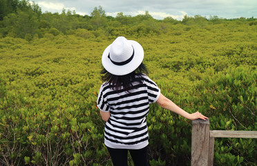 One Female Tourist Admiring Vibrant Green Golden Mangrove Field in Rayong Province of Thailand