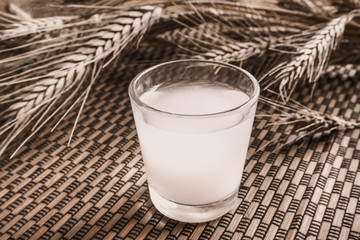 A glass of Japanese sake on a bamboo background. Vintage.