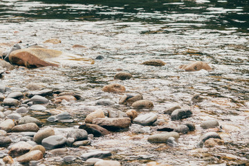 Stones and pebbles in the clear water of a mountain river
