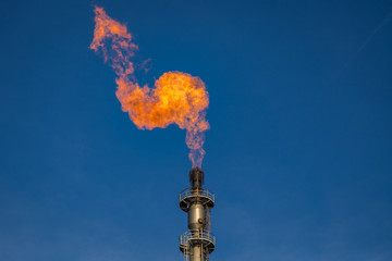 Flare of a coking plant with blue sky