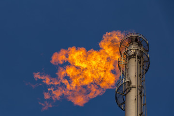 Flare of a coking plant with blue sky