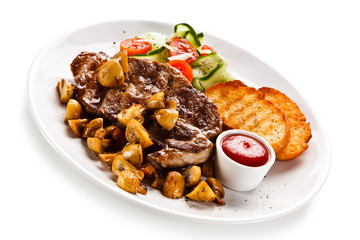Grilled steak with toasts and vegetables on white background