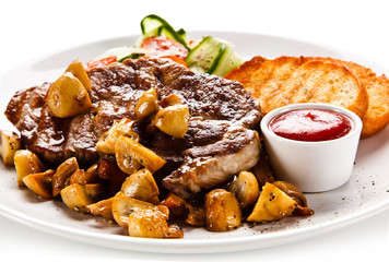 Grilled steak with toasts and vegetables on white background