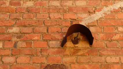 Rusty iron on the wall of red brick.