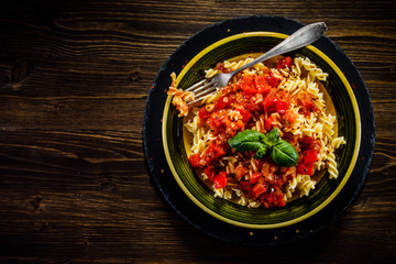 Pasta with tomato sauce on wooden table 
