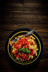Pasta with tomato sauce on wooden table 