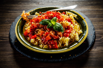 Pasta with tomato sauce on wooden table 