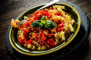 Pasta with tomato sauce on wooden table 