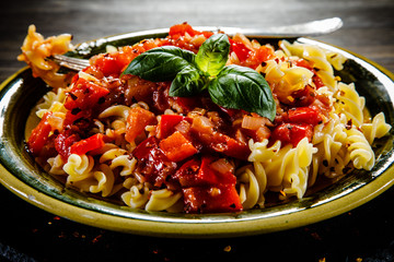 Pasta with tomato sauce on wooden table 