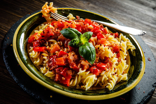 Pasta with tomato sauce on wooden table 