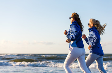 Middle-aged women running on beach