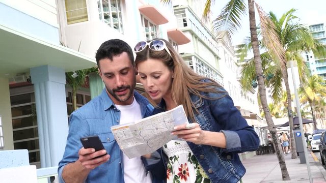 Young couple looking at tourist map in Miami
