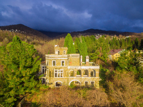 Drone view of the abandoned old mansion called Dacha Kvitko and mountains in the rays of the setting sun, Sochi, Russia
