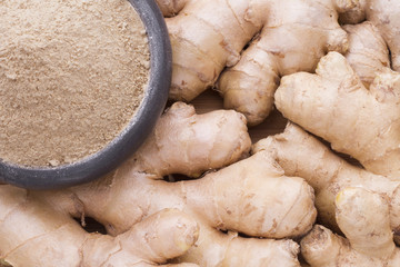 root, powder and grated ginger on wooden background