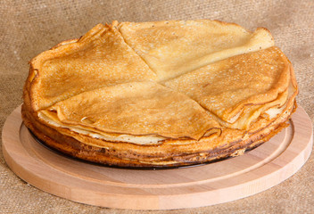 Fried pancakes lie on a wooden cutting board. The concept of baking. Horizontal image.