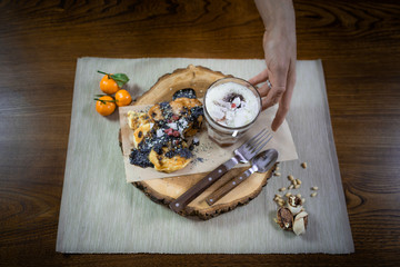 Beautiful dish for breakfast on the stylish wooden tray. Fresh protein pancakes and parfait with fruits decorated with toppings and nuts on the wooden table. Final touch. Ready to eat. Close up view.