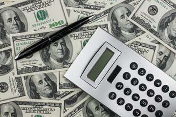 Fototapeta premium Business background. Calculator and pen lying on the background of money.