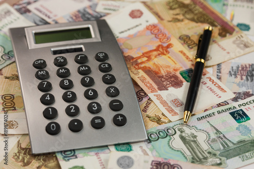 Business Background Calculator And Pen Lying On The Of Calculator And Pen Lying On The Background Of Money