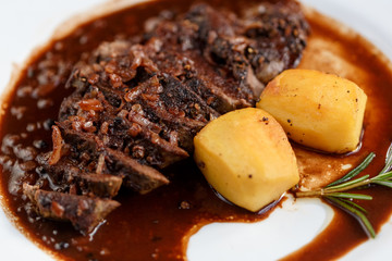 meat on a plate with potatoes and seasonings