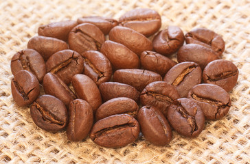 Brown coffee beans macro on burlap fabric background