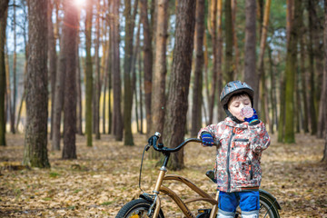 Young boy with bicycle with drinking clear water
