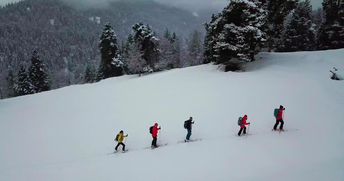 Men go skitour in deep snow forest