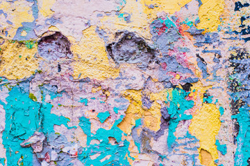 Concrete wall with remains of paint of different colors - grunge texture, background