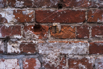 Old vintage brick wall with the remains of paint - grunge texture, background
