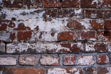 Old vintage brick wall with the remains of paint - grunge texture, background