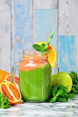 Fresh Green Smoothies with blood oranges. Green smoothie jar on the light background