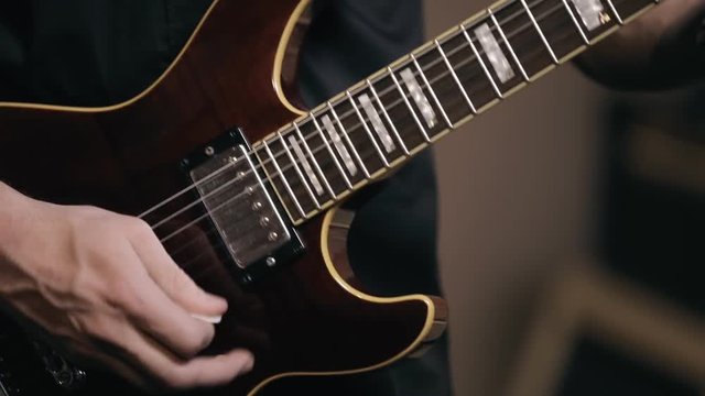 Unidentified person's hand plays on electronic guitar. Rocker musician.