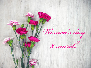 Pink flowers on a wooden bright background to celebrate the Women's Day
