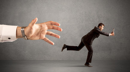 Businessman running from hand