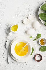 Ingredients for scrambled eggs with spinach and turmeric on the background. Top view. Copy space.