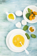 Ingredients for scrambled eggs with spinach and turmeric on the background. Top view. Copy space.