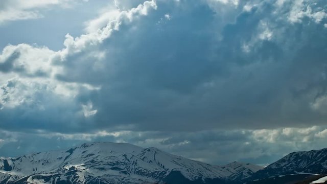 Beautiful Aerial View. Winter Snow Mountains And Fast Clouds Closeup