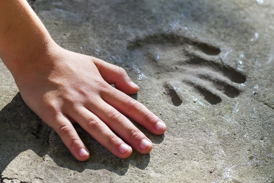 Childs hand and memorable handprint in concrete