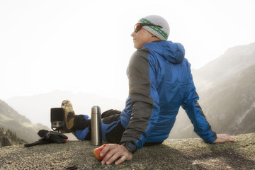 Hiker eats an apple during a break and prepares a hot tea
