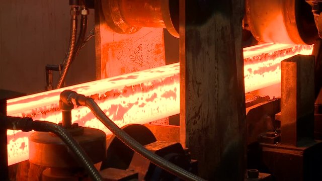 Hot steel ingots on conveyor. Foundry casting process, black metallurgy manufacture.