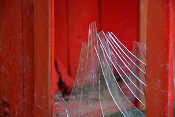 Glasscheibe zerbrochen im roten Fensterrahmen 