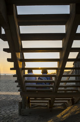 Elder tourist couple enjoying the magnificent sunrise of Islantilla, Huelva, Spain