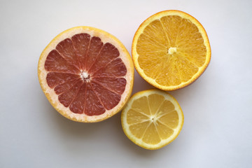 Fototapeta na wymiar Orange, lemon and grapefruit. Sliced fruit on a blue background.