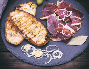 pieces of jamon and toast from white wheat bread